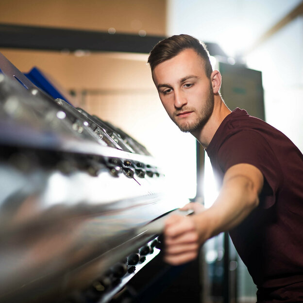 Mitarbeiter arbeitet an einer Maschine in der Werkstatt