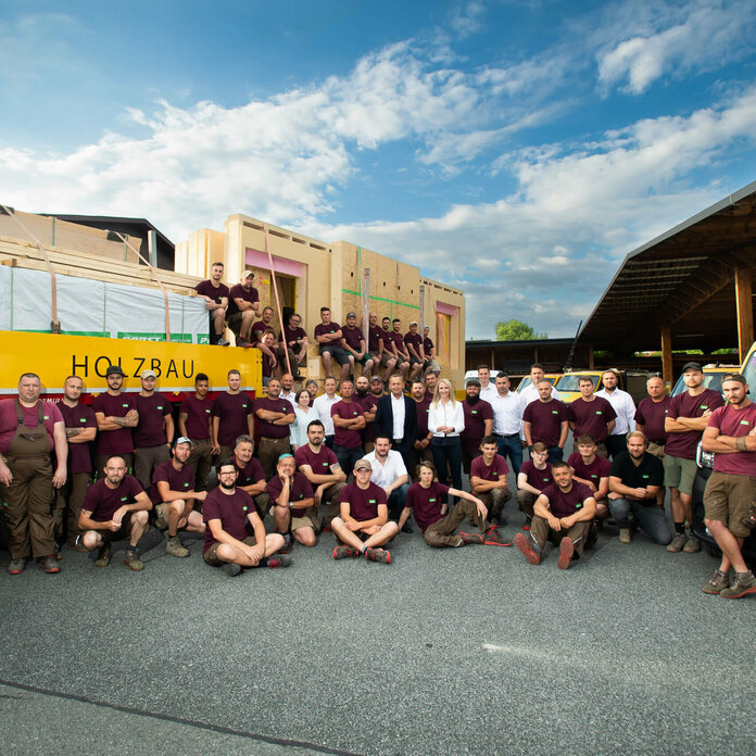 Komplettes Strobl Team steht vor einem beladenen LWK mit Holz