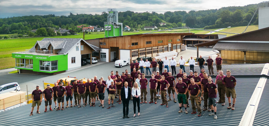 Team der Firma Strobl steht auf dem Dach des Firmengebäudes